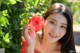 A woman in a red dress holding a red flower.