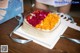 A cake with fruit on top of it sitting on a table.