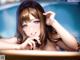 Anime girl in a bathtub with her hand on her chin.